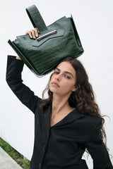 Crossbody handbag in forrest green croc embossed leather on model