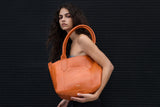 Tote bag in orange croc embossed leather on model